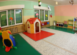 Children's playroom with colorful toys and a small playhouse.